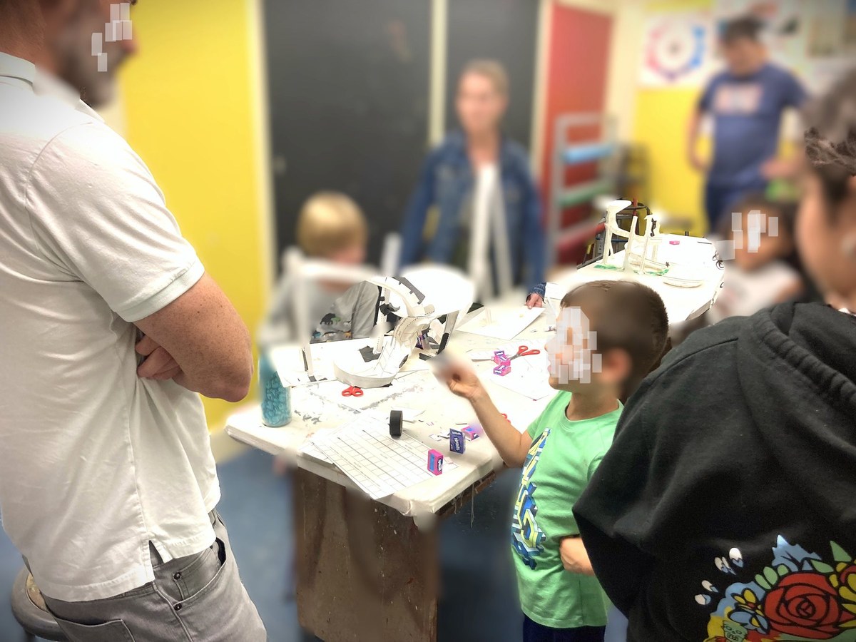 Participants testing a paper engineering activity at a worktable.