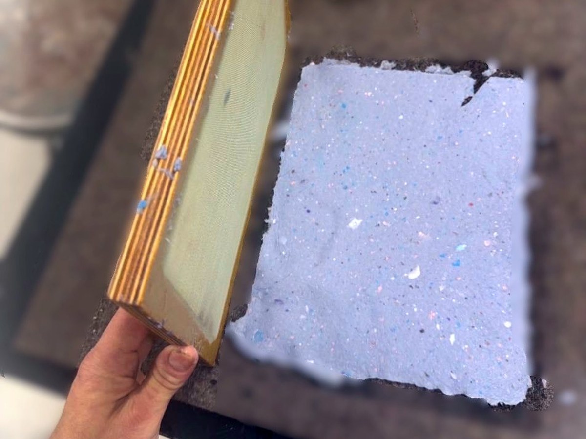 A newly formed sheet of handmade paper being released from a papermaking frame.
