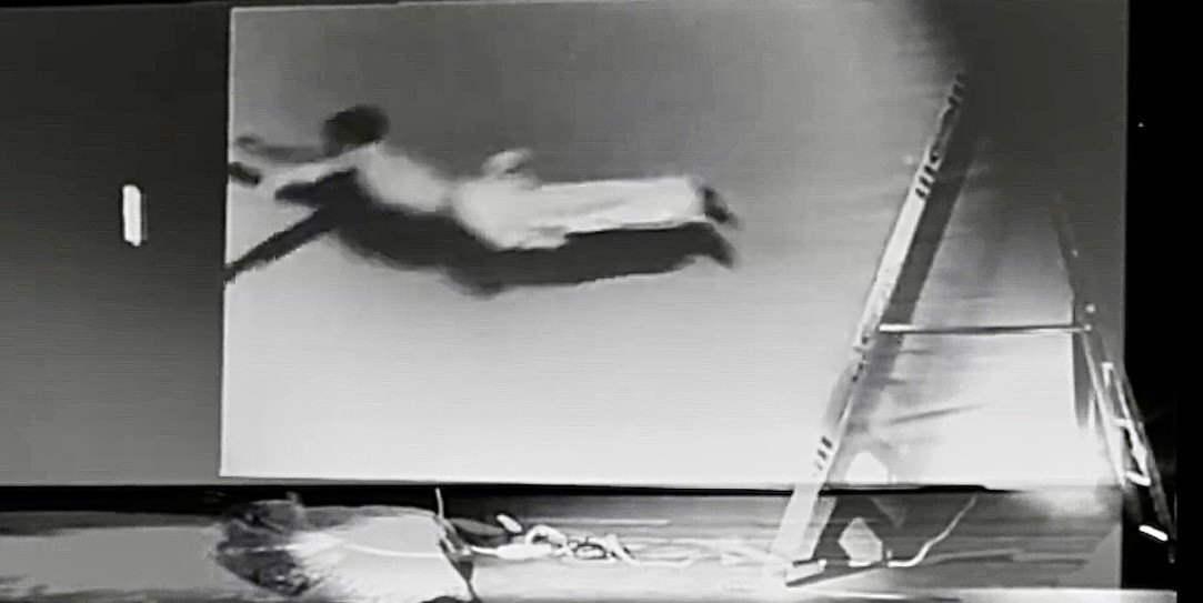Black-and-white performance video projected in a gallery.